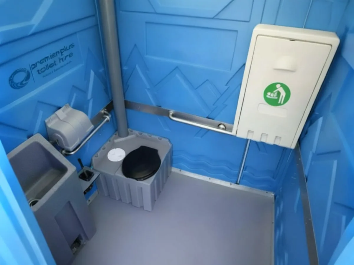 Accessible portable toilet cubicle with low-level basin, grab rails and baby change unit