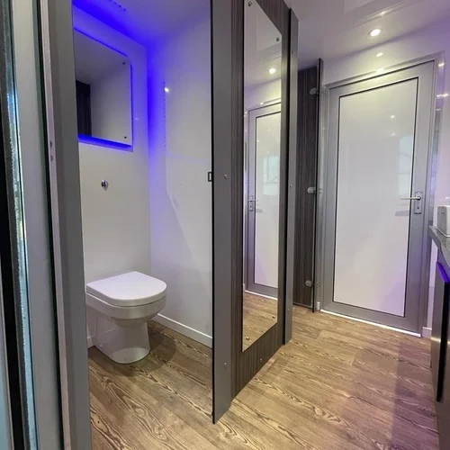 Luxury trailer interior with toilet cubicle and blue LED accent lighting