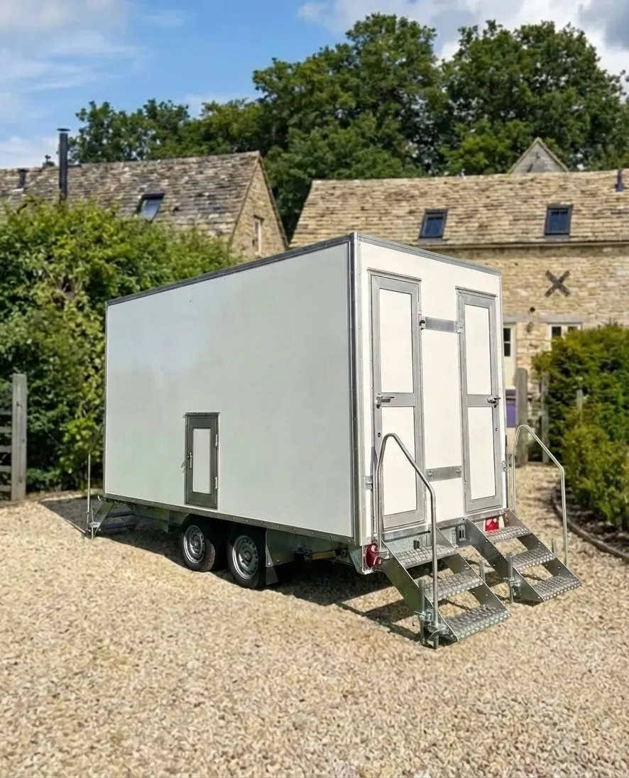 Luxury portable toilet trailer outside a Cotswolds stone cottage