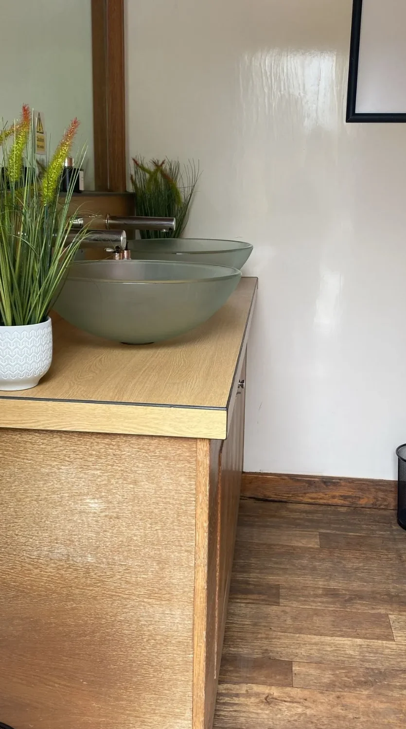 3+1 luxury trailer vanity area showing Zebrano cabinetry and wood flooring